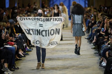 Protester with climate change banner crashes Louis Vuitton show